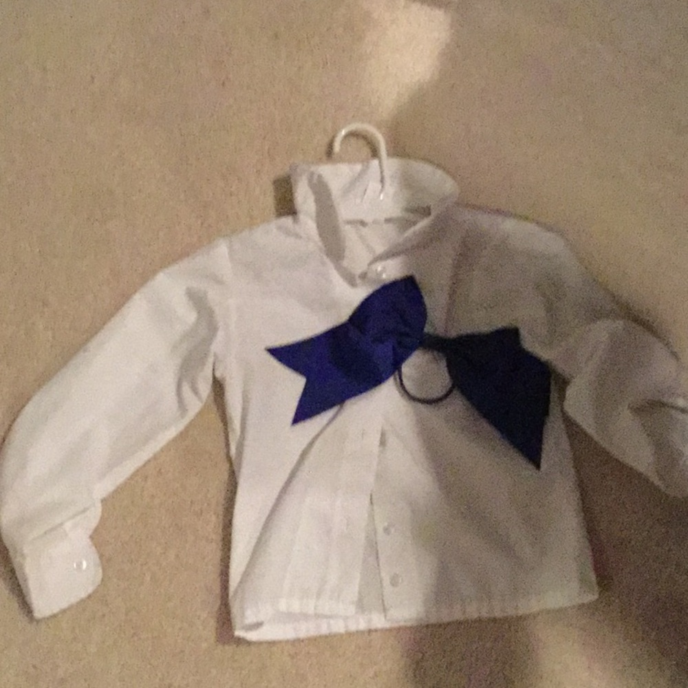 a white long sleeve shirt with blue bow